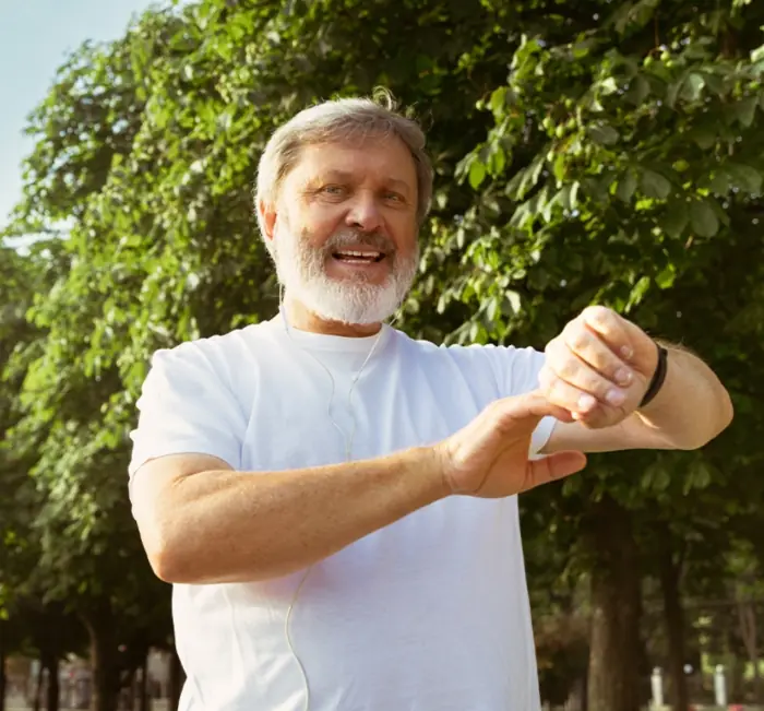Smiling man checking his watch during a walk